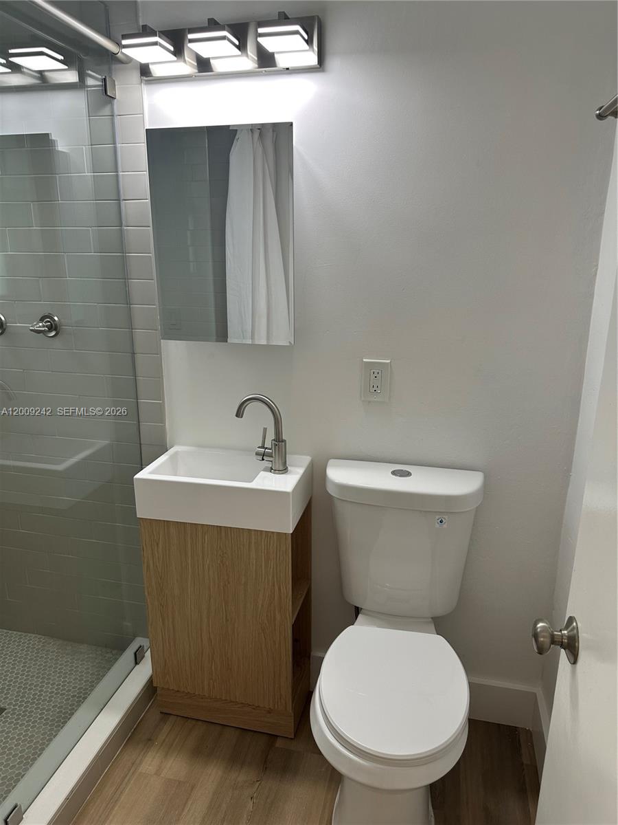 6310 Southwest 79th Street, Unit 1 South Miami, FL 33143 - Photo 2 of 8 a bathroom with a sink a toilet and shower