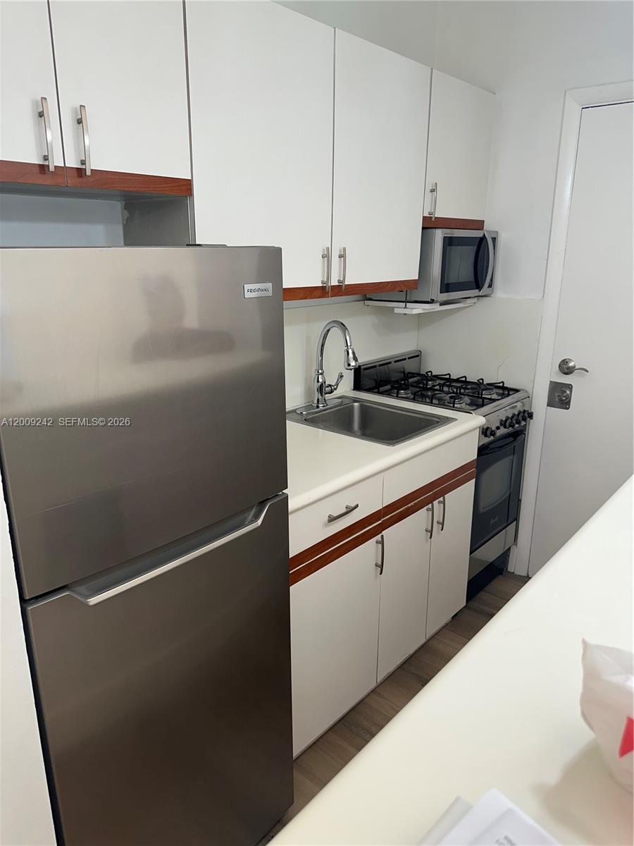 6310 Southwest 79th Street, Unit 1 South Miami, FL 33143 - Photo 5 of 8 a kitchen with stainless steel appliances granite countertop white refrigerator a stove a sink and dishwasher