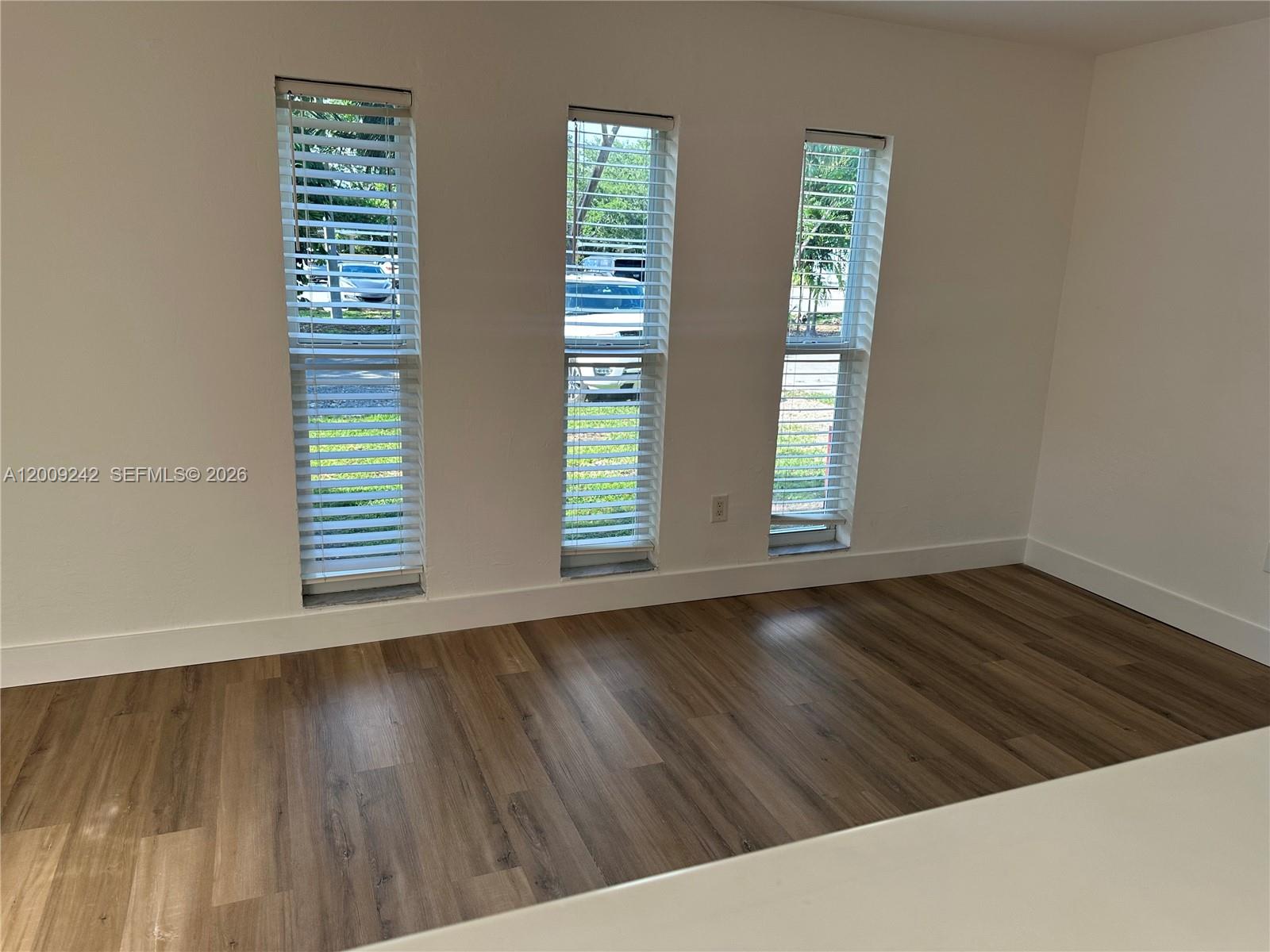 6310 Southwest 79th Street, Unit 1 South Miami, FL 33143 - Photo 6 of 8 a view of an empty room with wooden floor and a window
