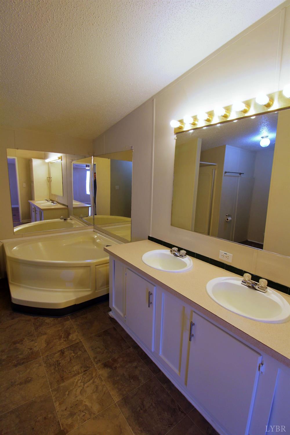 1908 Holiday Lake Road Appomattox, VA 24522 - Photo 16 of 35 a bathroom with a double vanity sink and a mirror