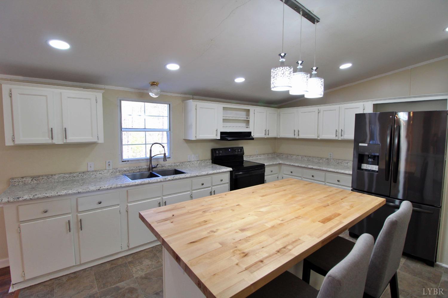 1908 Holiday Lake Road Appomattox, VA 24522 - Photo 3 of 35 a kitchen with stainless steel appliances granite countertop wooden floor window and cabinets
