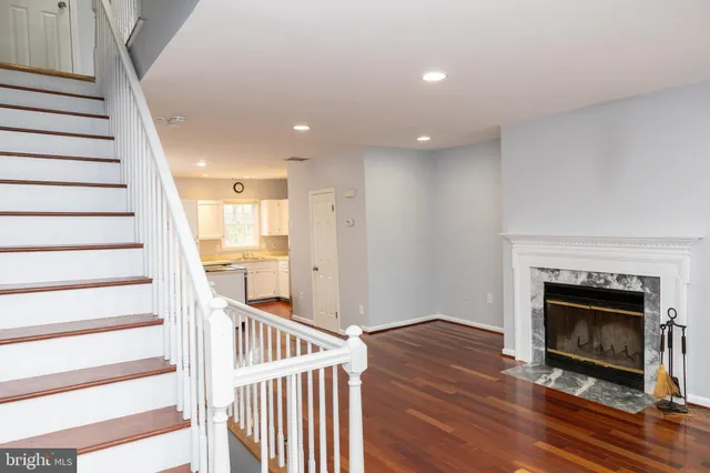 a view of an empty room with wooden floor fire place