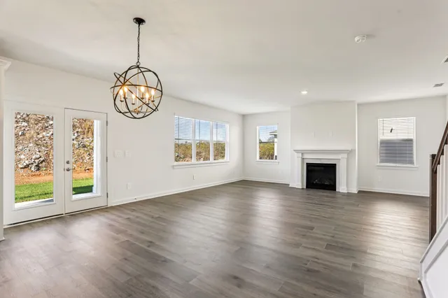a kitchen with a refrigerator a stove and wooden floor