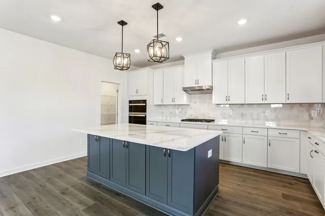 a kitchen with stainless steel appliances granite countertop a stove a sink a refrigerator and a wooden floors