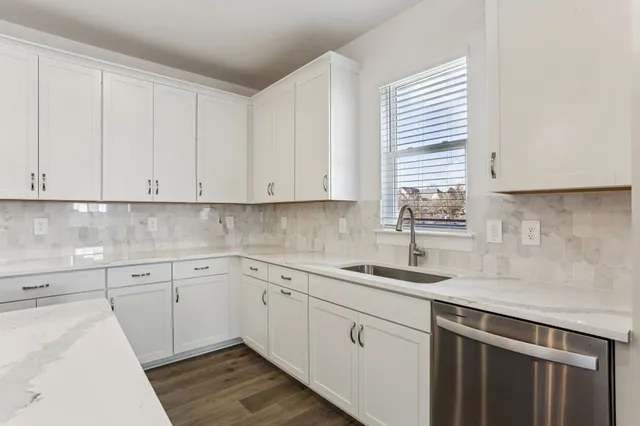 a kitchen with stainless steel appliances granite countertop a sink and dishwasher a refrigerator with wooden cabinets
