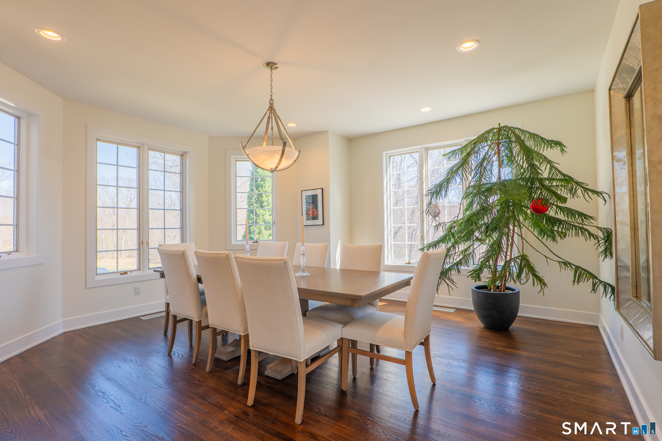 216 Kuhne Road Southbury, CT 06488 - Photo 8 of 40 a dining room with furniture potted plants and wooden floor