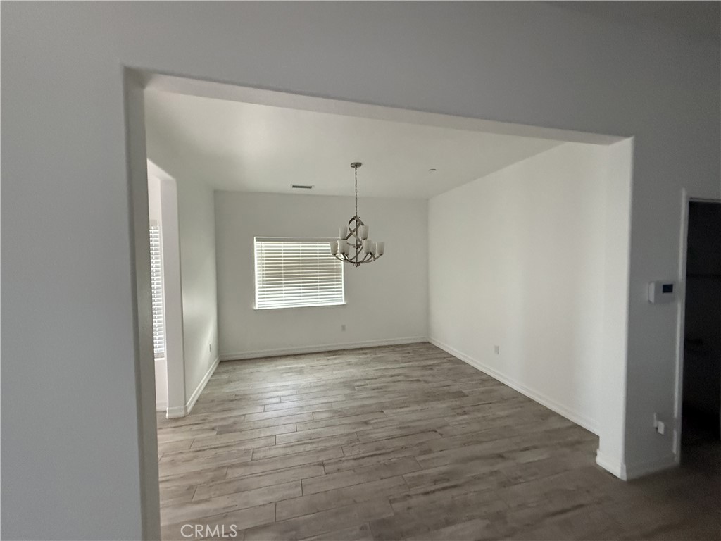 9591 Burbank Road Phelan, CA 92371 - Photo 6 of 11 a view of an empty room with window and wooden floor