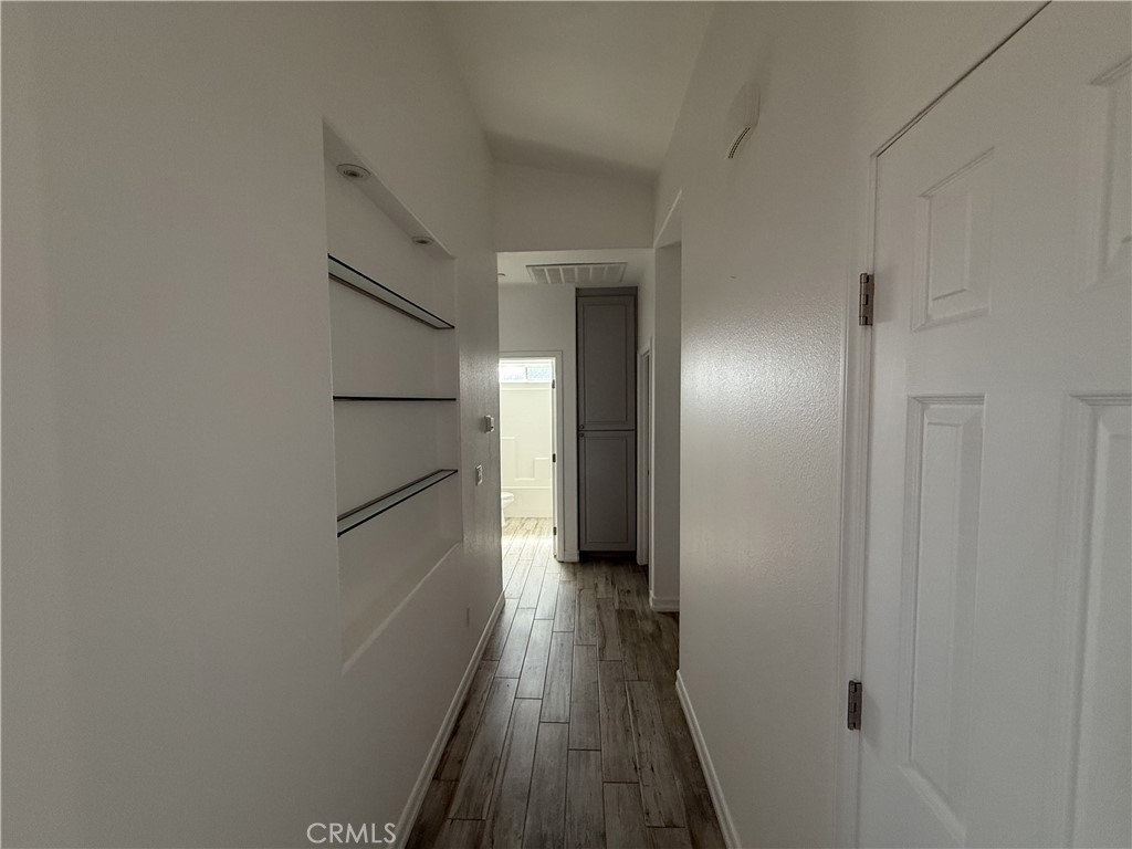 9591 Burbank Road Phelan, CA 92371 - Photo 8 of 11 a view of a hallway with wooden floor and staircase