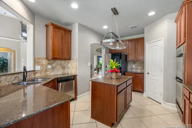 a kitchen that has a lot of counter top space and stainless steel appliances