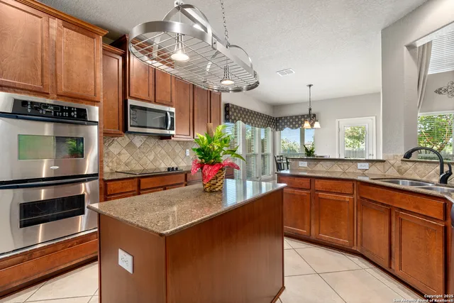 a kitchen with stainless steel appliances a stove sink microwave and cabinets