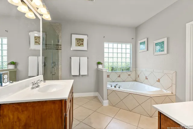 a spacious bathroom with a tub sink and mirror