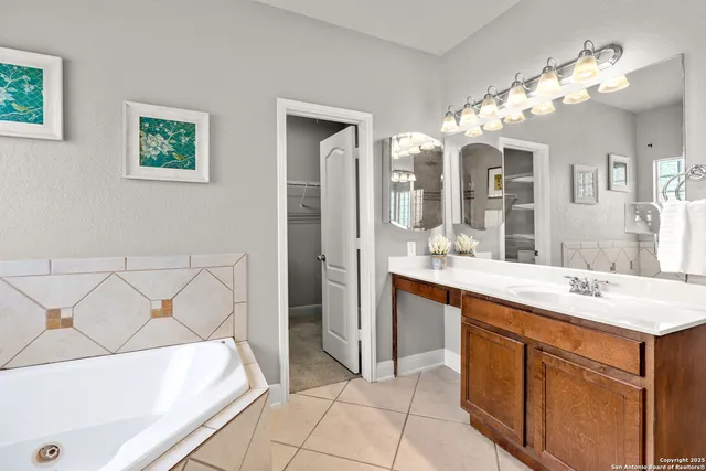 a spacious bathroom with a sink a mirror and a bathtub
