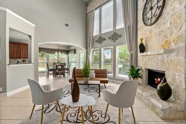 a living room with furniture a fireplace a clock and a large window
