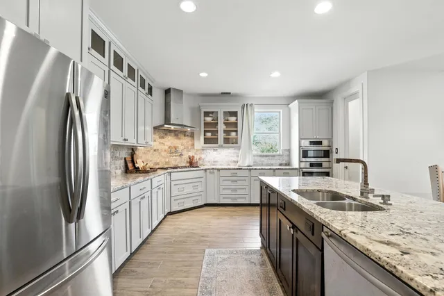 a kitchen with granite countertop a sink stainless steel appliances and cabinets