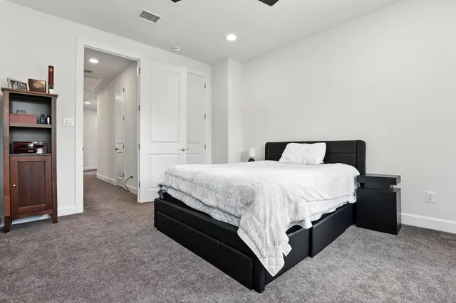 a spacious bedroom with a bed and a cabinets