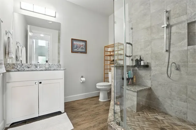 a bathroom with a granite countertop toilet sink and shower