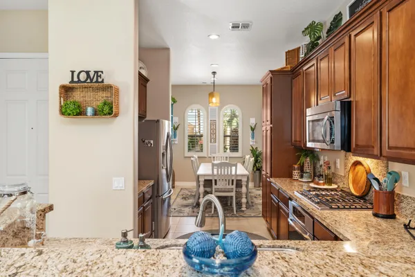 a kitchen with stainless steel appliances kitchen island granite countertop a sink stove and refrigerator