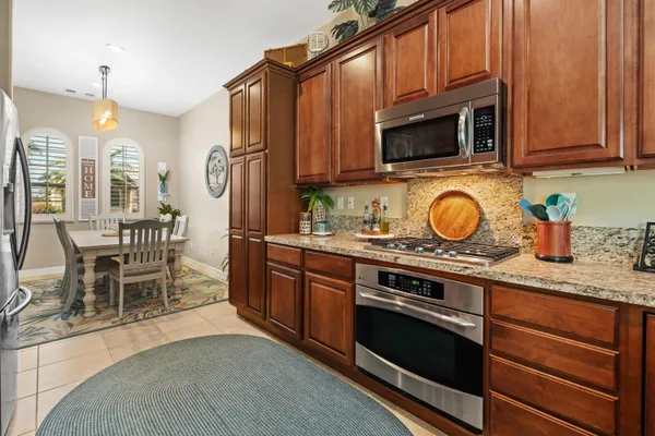 a kitchen with granite countertop wooden cabinets stainless steel appliances and a counter space