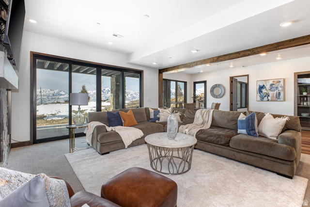 1282 Chimney Rock Road, Unit 344 Heber City, UT 84032 - Photo 32 of 55 Spacious living area featuring large sliding glass doors, exposed wood beams, recessed lighting, a stone fireplace, and light-toned carpeting