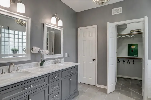 a bathroom with double vanity sinks a vanity and a mirror
