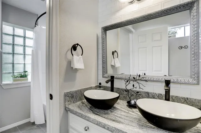 a bathroom with a granite countertop sink and a mirror