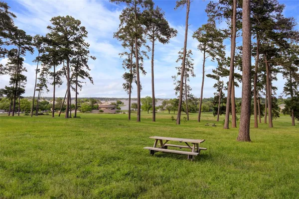 a white house with a big yard and large trees