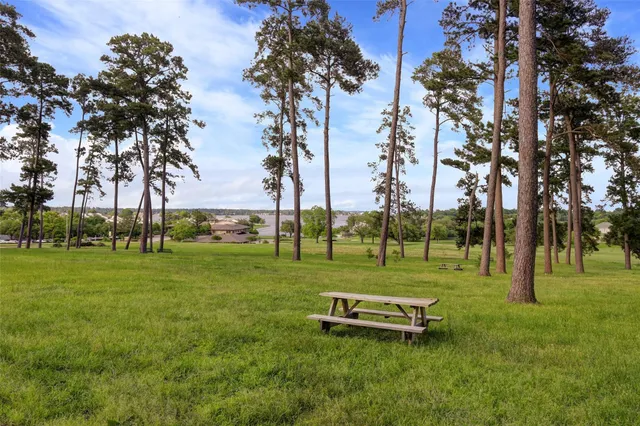 a white house with a big yard and large trees