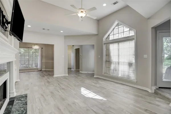 a view of an empty room with a fireplace and a window