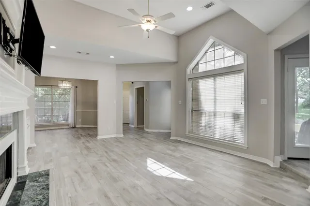 a view of an empty room with a fireplace and a window