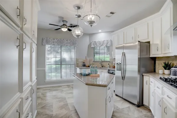 a kitchen with stainless steel appliances granite countertop a refrigerator a oven and a refrigerator