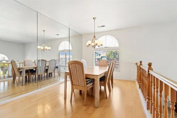 a view of a dining room with furniture a chandelier and wooden floor