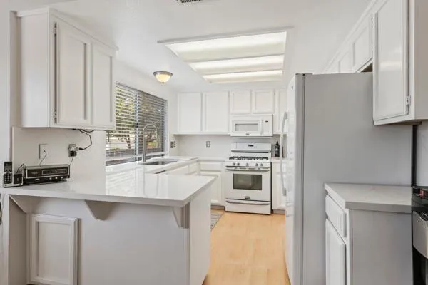 a kitchen with stainless steel appliances white cabinets and a refrigerator