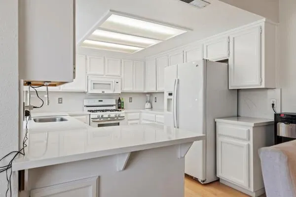 a kitchen with stainless steel appliances granite countertop a stove a sink and a refrigerator