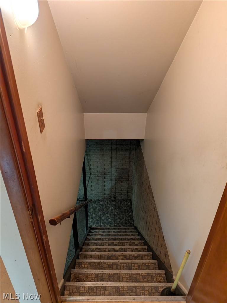 1161 Gulf Road Elyria, OH 44035 - Photo 26 of 34 Stairwell featuring patterned tread coverings and a wood handrail