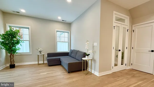 a view of a hallway with wooden floor and a potted plant