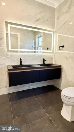a bathroom with a toilet sink vanity and mirror