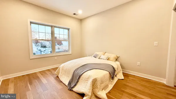 an empty room with wooden floor and a window