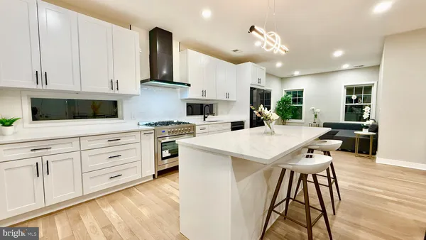 a kitchen with granite countertop a stove and a white cabinets