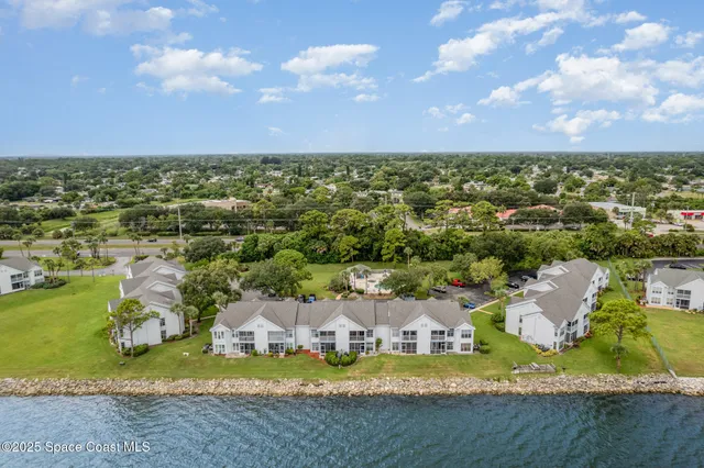 a aerial view of a house with a yard and lake view