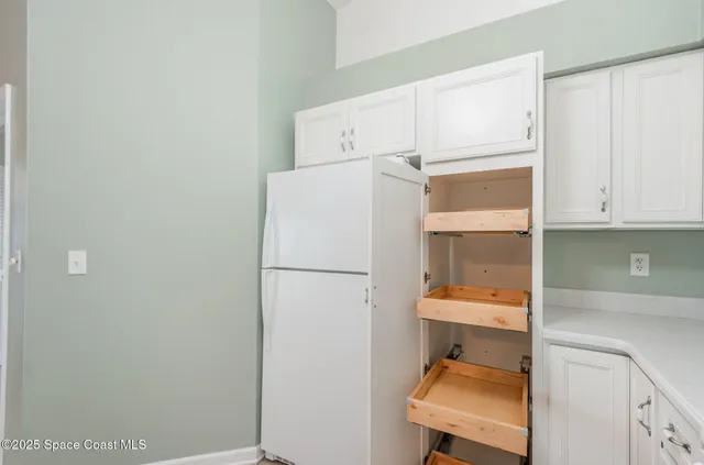 a room with a refrigerator and cabinets