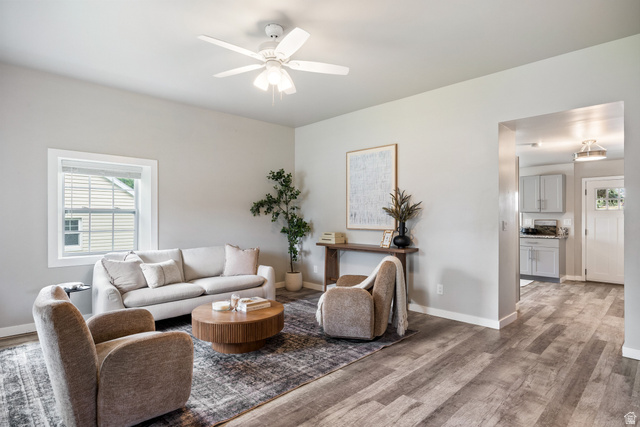 Neutral color palette, wood-finish flooring, white trim details, recessed lighting, and a ceiling fan with integrated lighting
