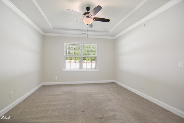 an empty room with a window and a ceiling fan