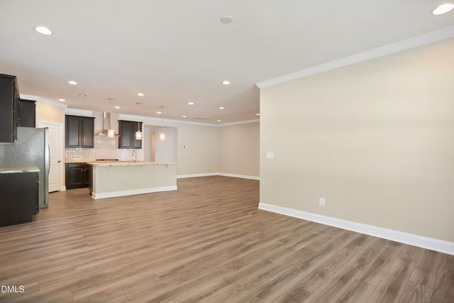 a view of kitchen with kitchen island a sink wooden floor and white stainless steel appliances