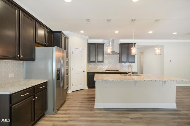 a large kitchen with stainless steel appliances granite countertop a stove a sink and a refrigerator