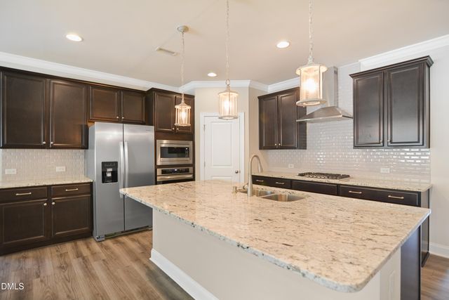 a kitchen with stainless steel appliances granite countertop a sink and a refrigerator