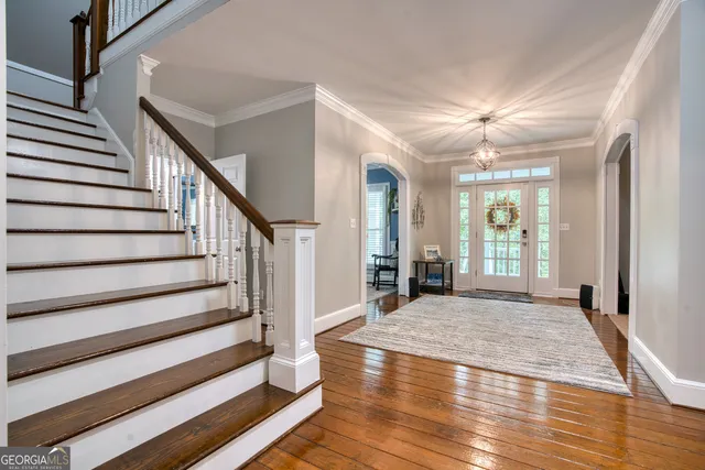 a view of an entryway with wooden floor and livingroom view