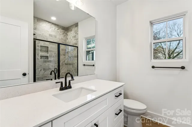 a bathroom with a sink toilet a mirror and shower