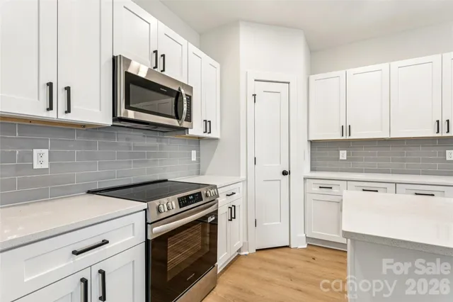 a kitchen with stainless steel appliances white cabinets and stove