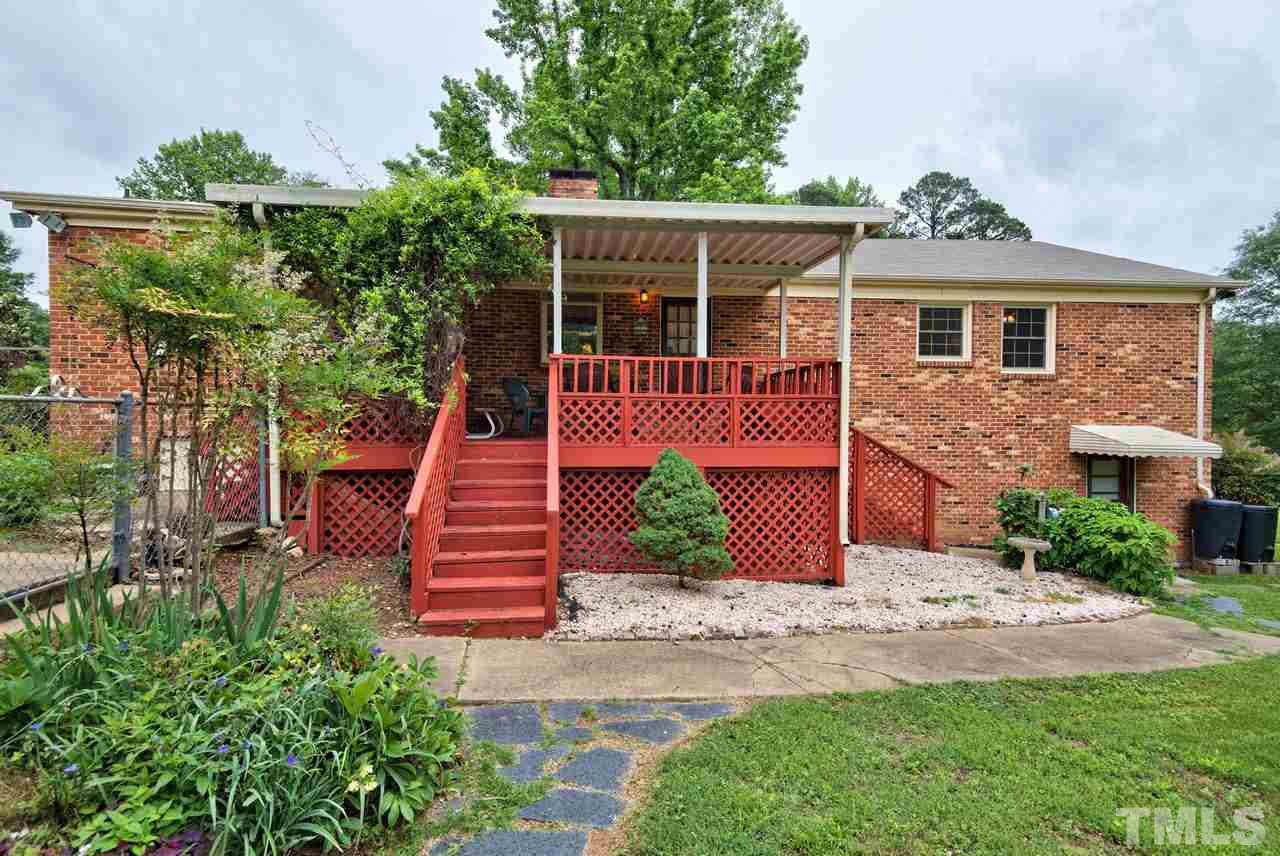 3607 Cole Mill Road Durham, NC 27712 - Photo 22 of 25 The back of the home shows the deck, entry to the basement, detailed landscaping and garden area.
