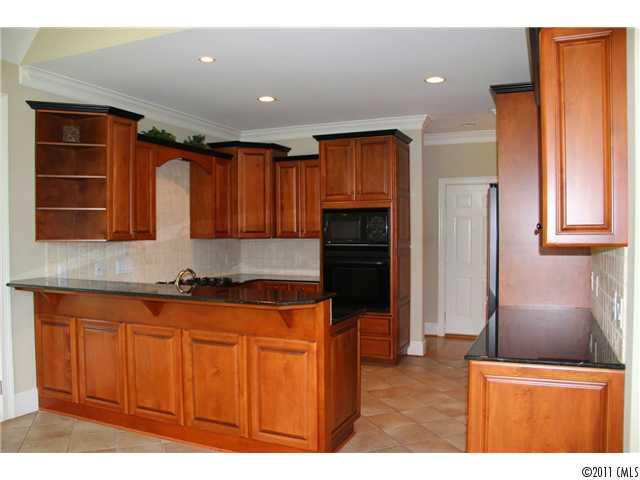 1838 Verdict Ridge Drive Denver, NC 28037 - Photo 6 of 16 a kitchen with stainless steel appliances granite countertop a refrigerator a sink a stove with wooden cabinets